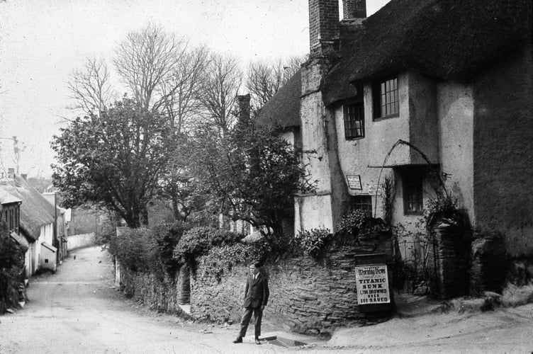 Thurlestone,  Bantham turn off and Post Office, man in the road and a notice about the sinking of the Titanic on the wall. 1912.